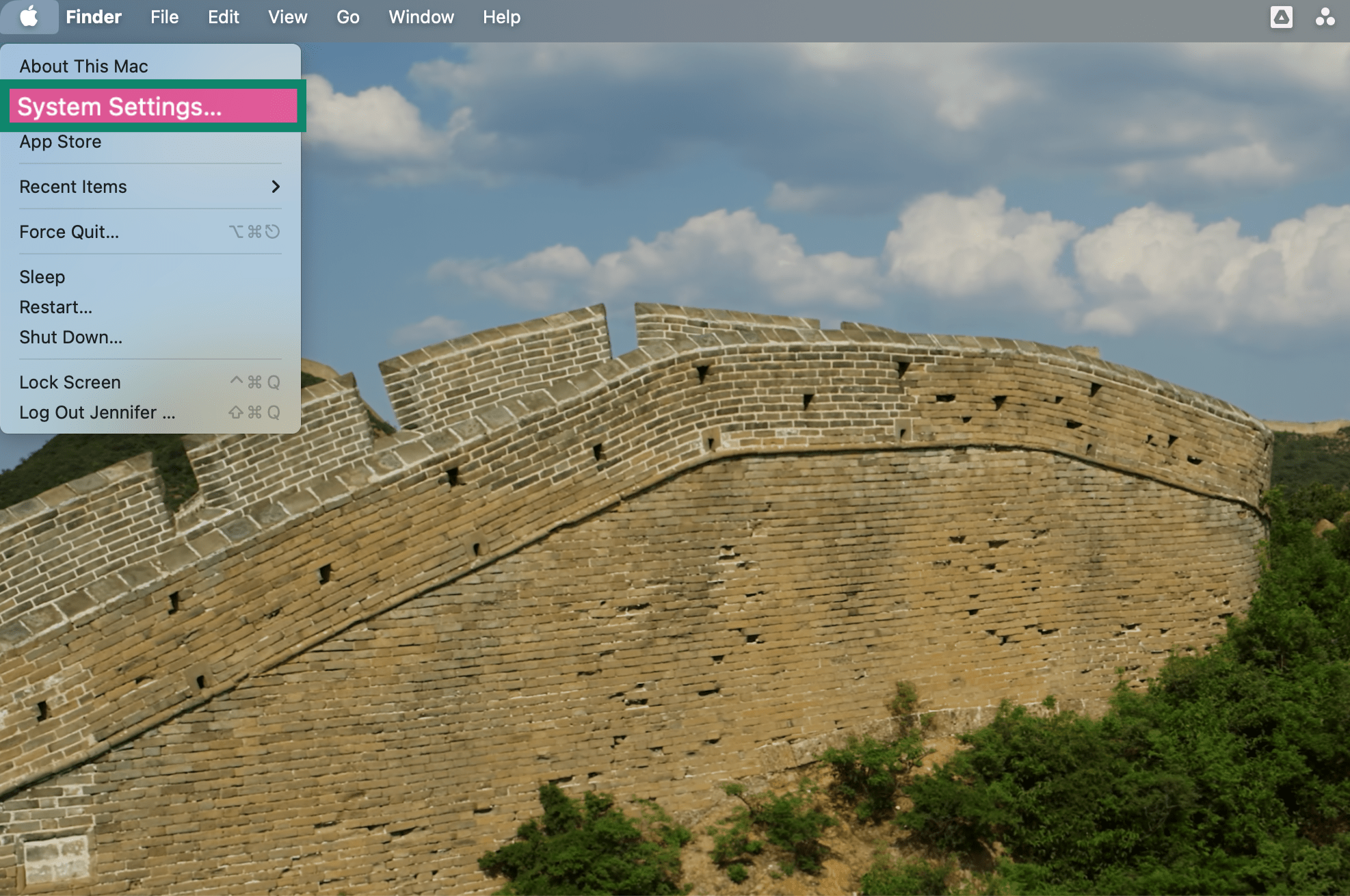 Apple menu open highlighting System Settings on a Mac desktop.